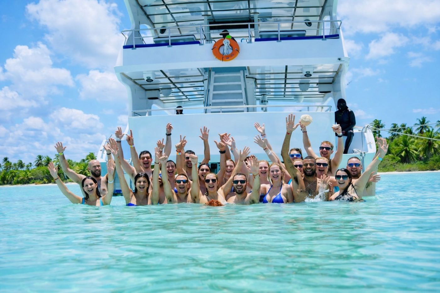 Guests celebrating in the water behind the boat